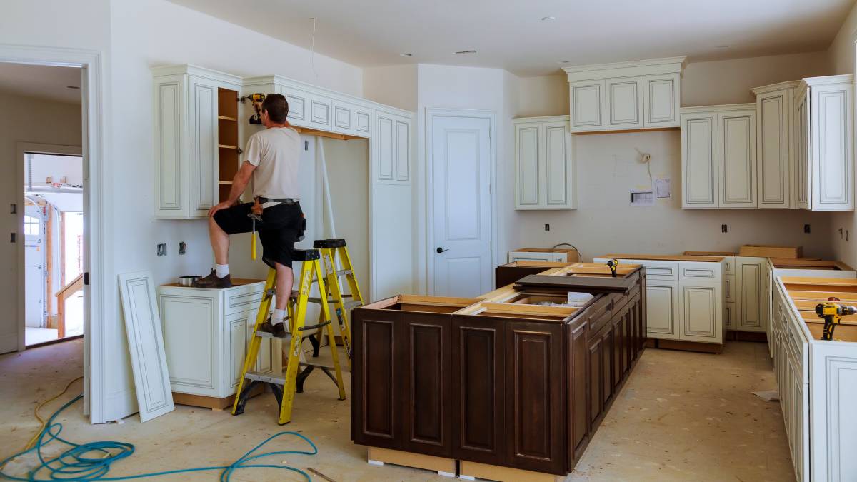 handyman fixing kitchen cabinet door