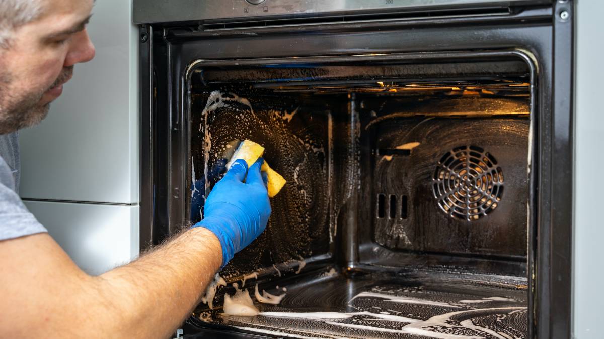 a tasker cleaning an oven