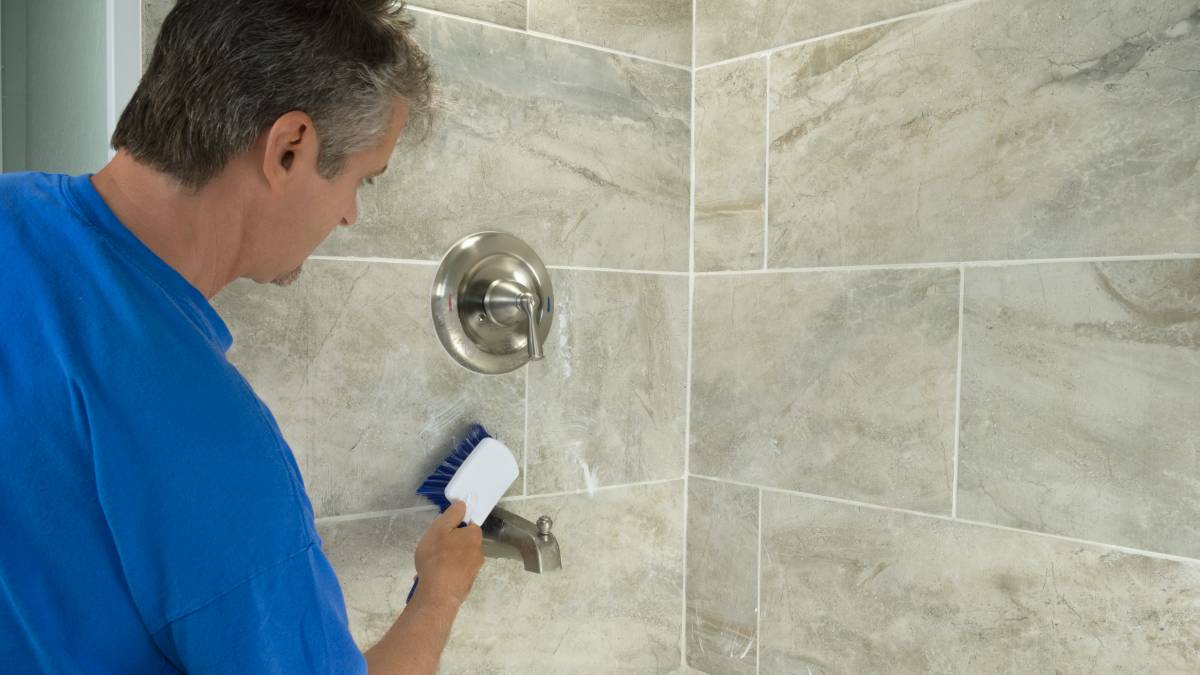 tasker cleaning tile grout in the bathroom