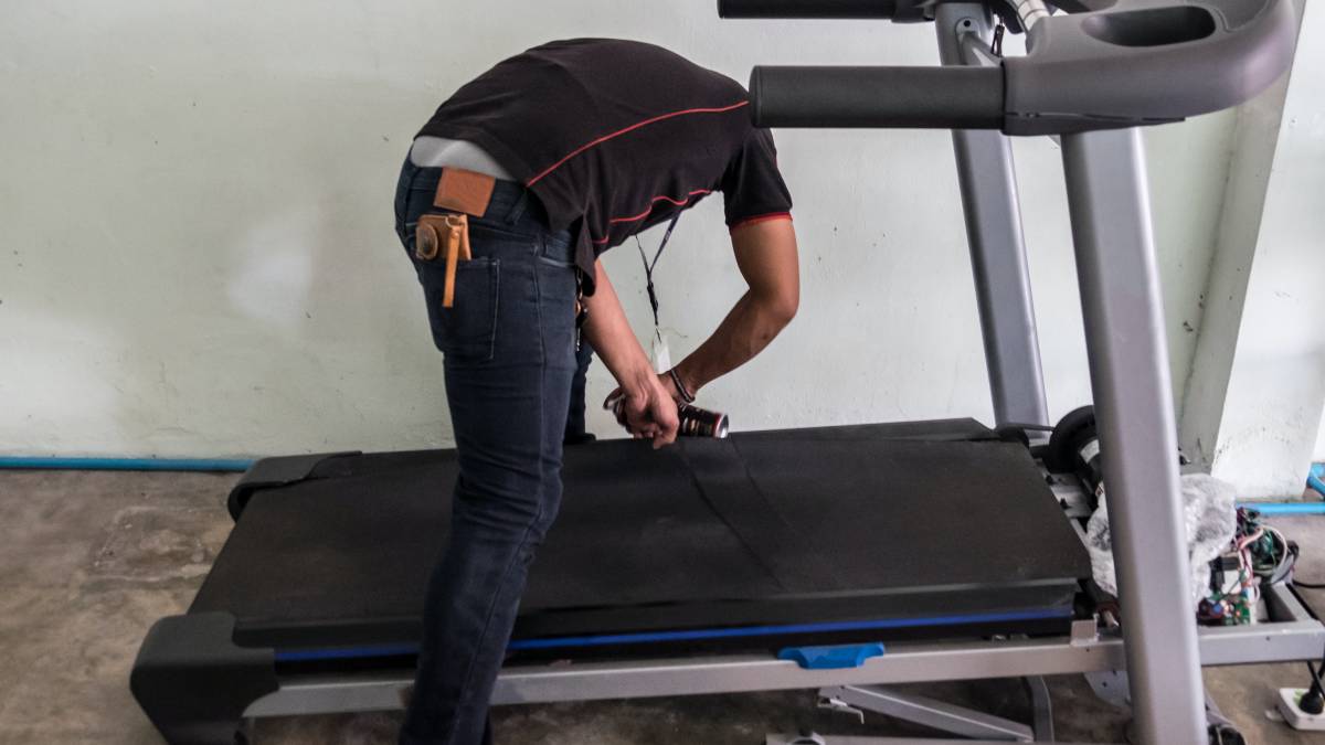 specialist repairing a treadmill