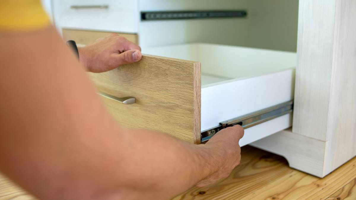 cabinet maker installing cabinet drawer