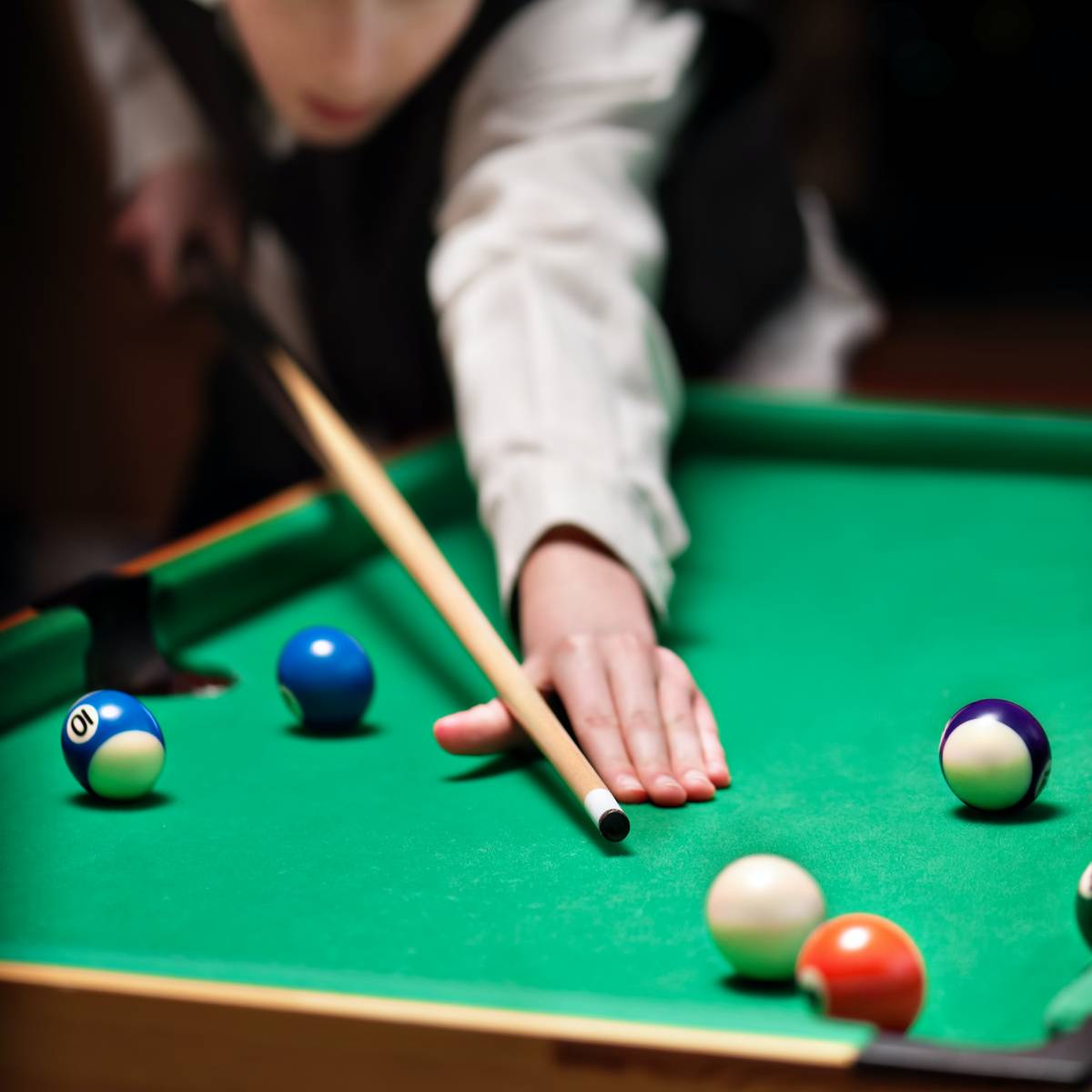 Pool table refelting cost - a player taking a shot on a green pool table.