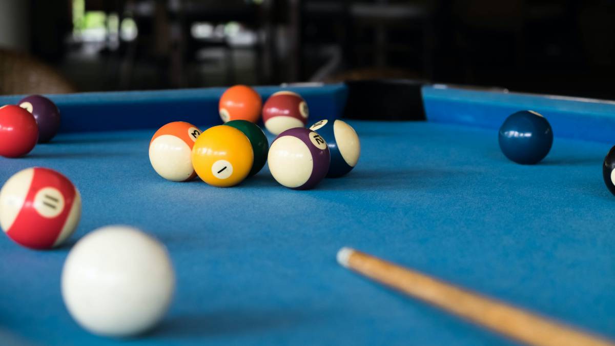 Pool table refelting cost - a blue pool table with scattered billiard balls.