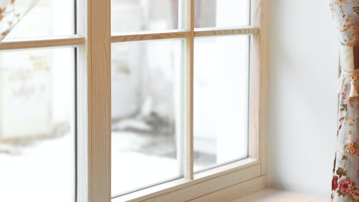 light wooden sash window with floral curtain