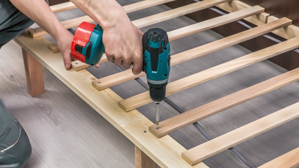 Handyman using a power drill to insert screws into wood