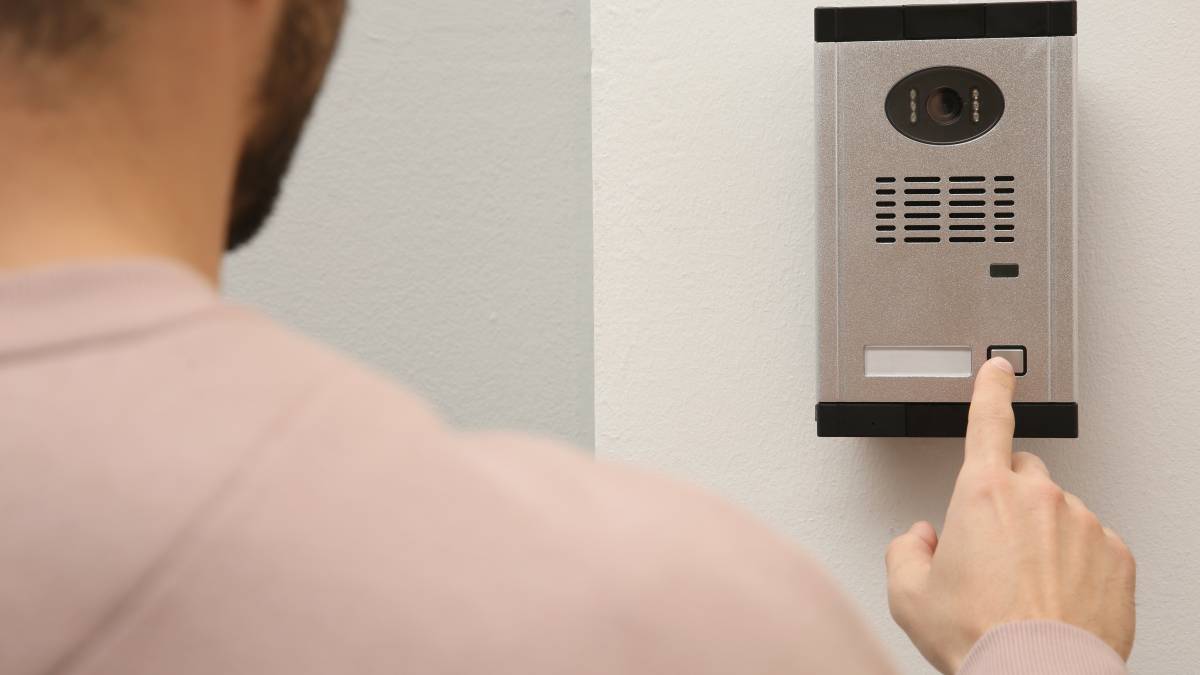 a man ringing a smart doorbell after installation