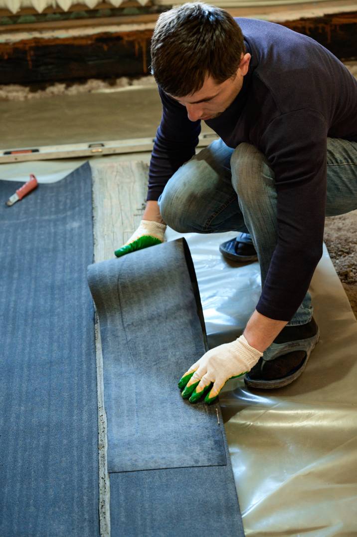 a man waterproofing a basement's flooring