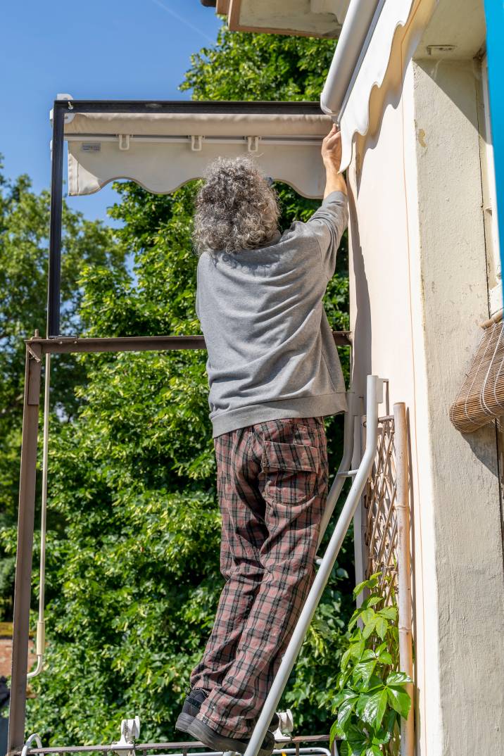 a handyman repairing a terrace awning