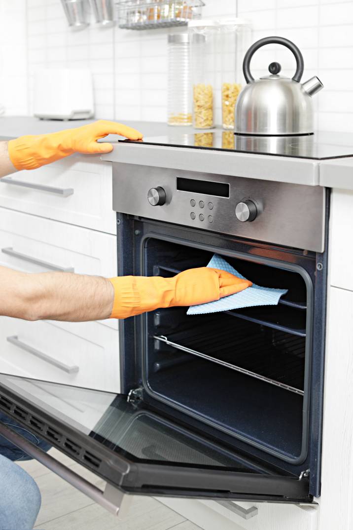 a man cleaning an oven