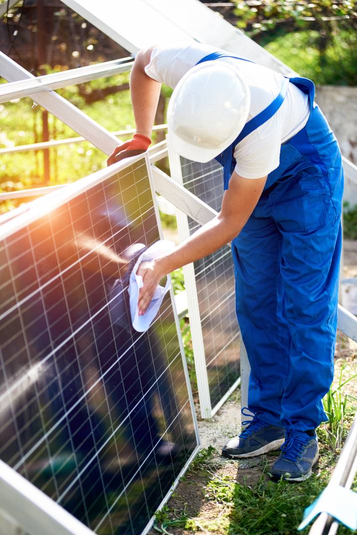 a handyman cleaning solar panels