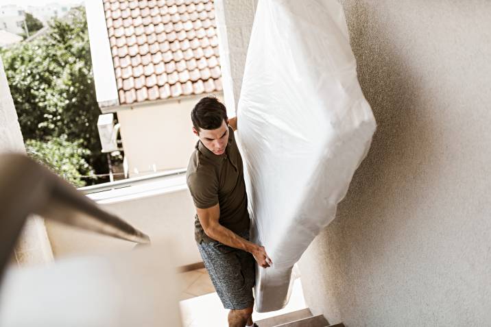 a man removing a mattress