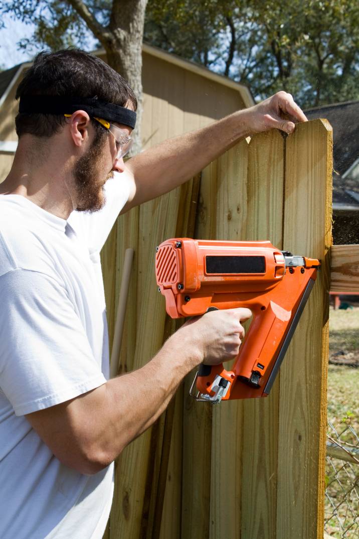 a man installing a wooden fence