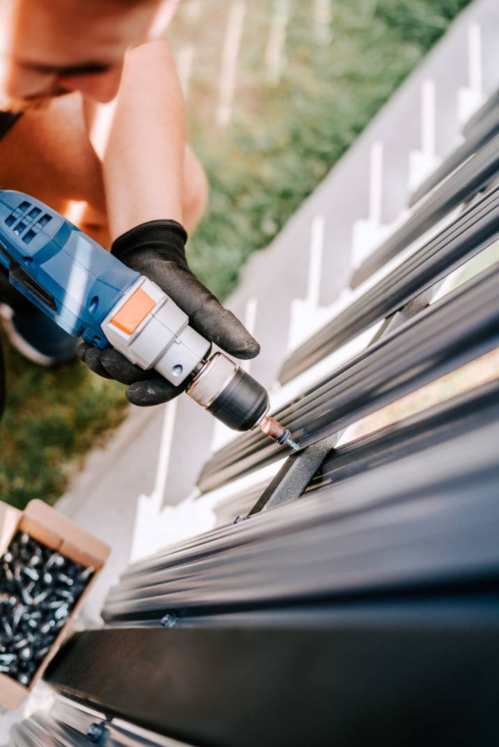 a man installing a metal fence