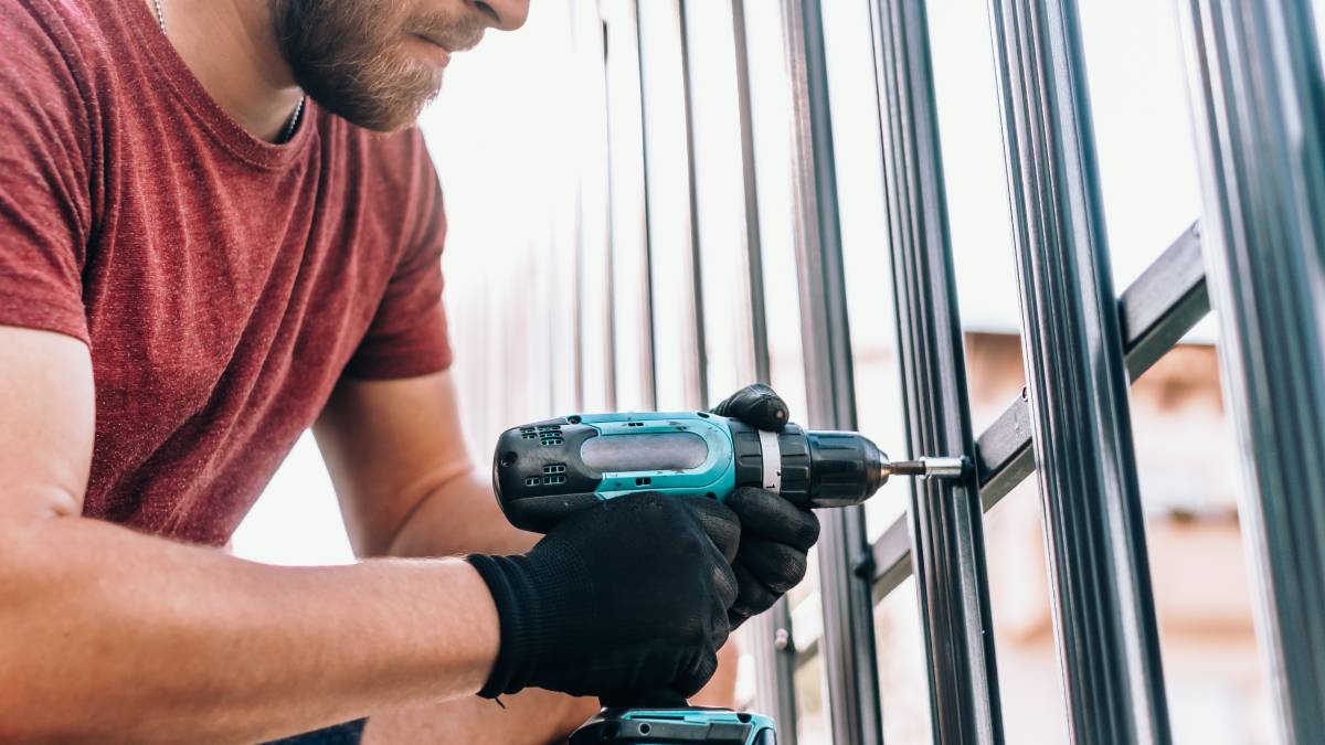 a man installing a metal fence