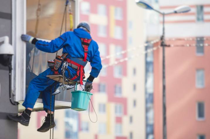 a man cleaning the windows of a high-rise building