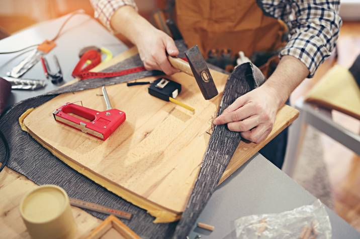 a man making new upholstery for a chair