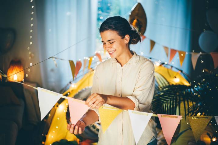 Smiling woman social worker decorating birthday party as a side hustle