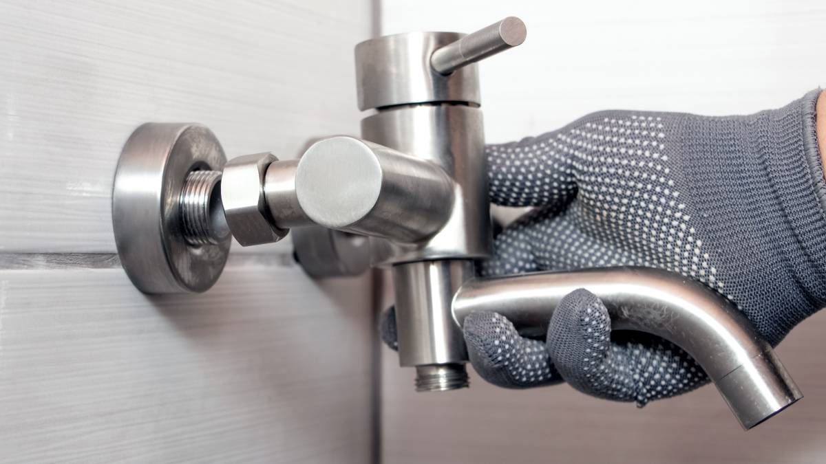 plumber installing bathroom faucet