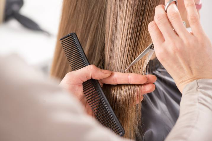 hair stylist cutting a woman's hair