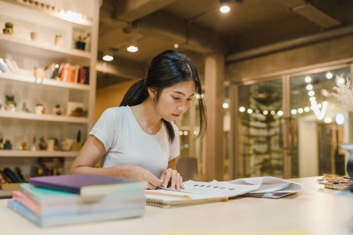 Student reading books in library at university