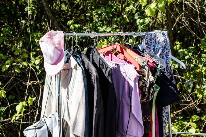 rack of old fashion female clothes on display for charity,donation,reusing or reselling for second life sold at garage sale, outdoors