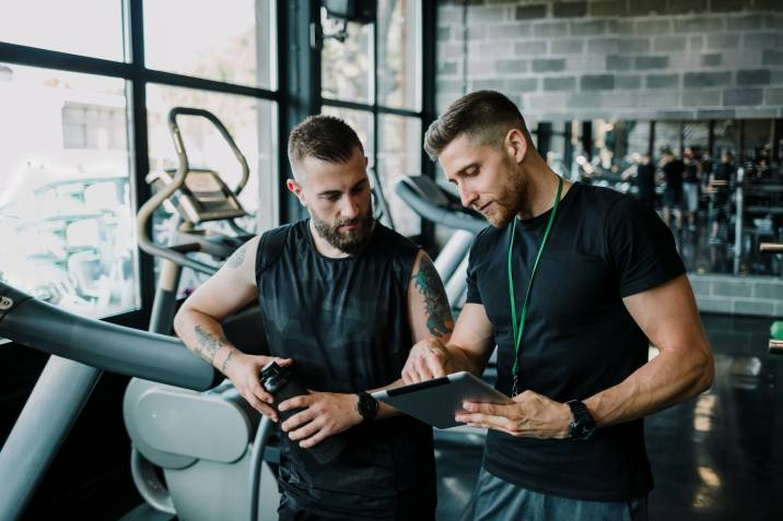 fitness instructor discussing his student's exercise routine