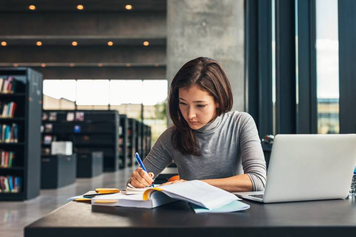 woman studying and taking down notes