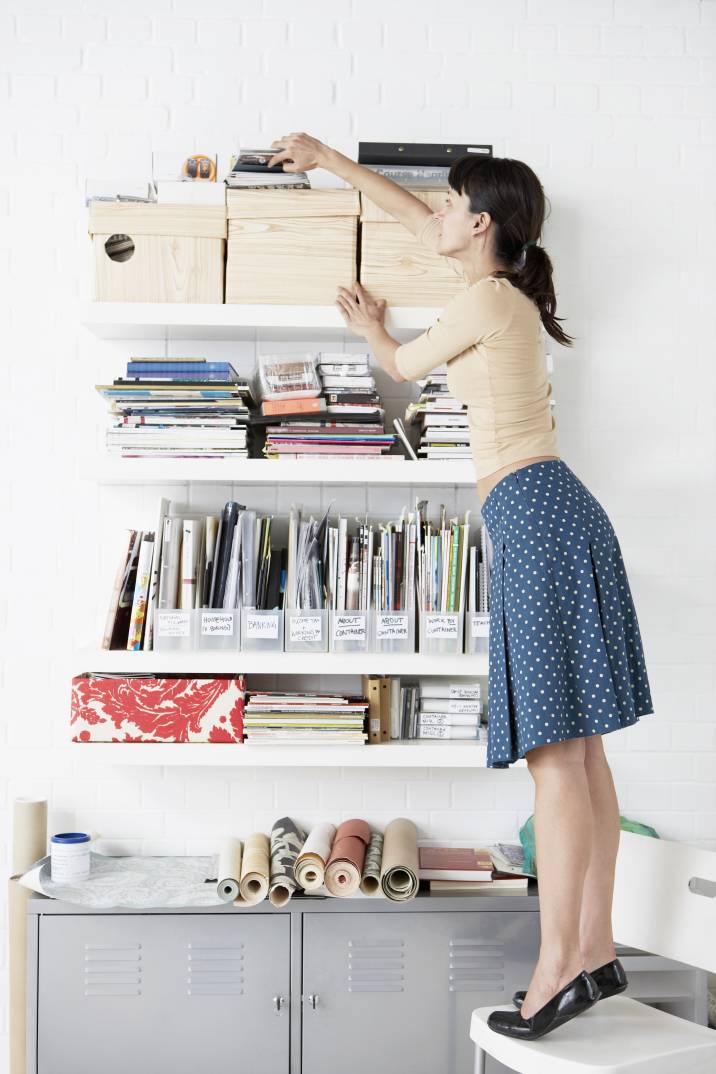 a woman organising her things on a floating shelf