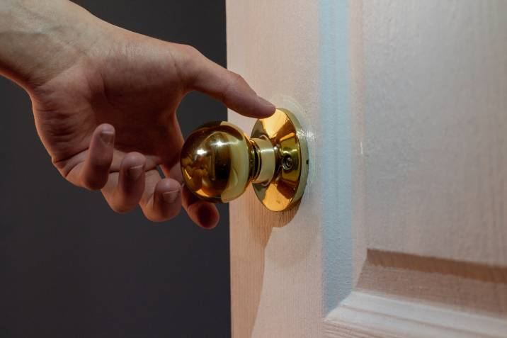 person reaching for a gold passage door knob