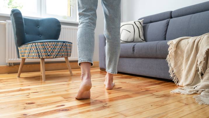 no-shoe policy indoors to lessen house odours, person walking barefoot in living room