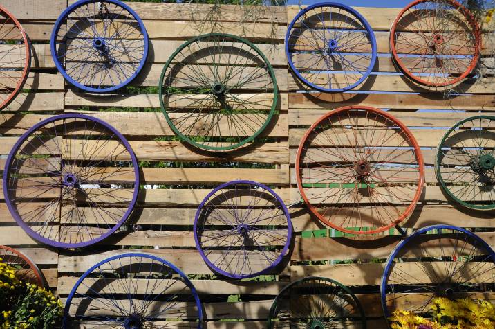 painted bike wheels repurposed as decor on a wooden wall