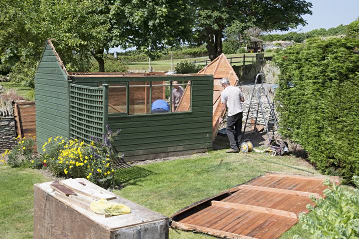 a man dismantling a shed
