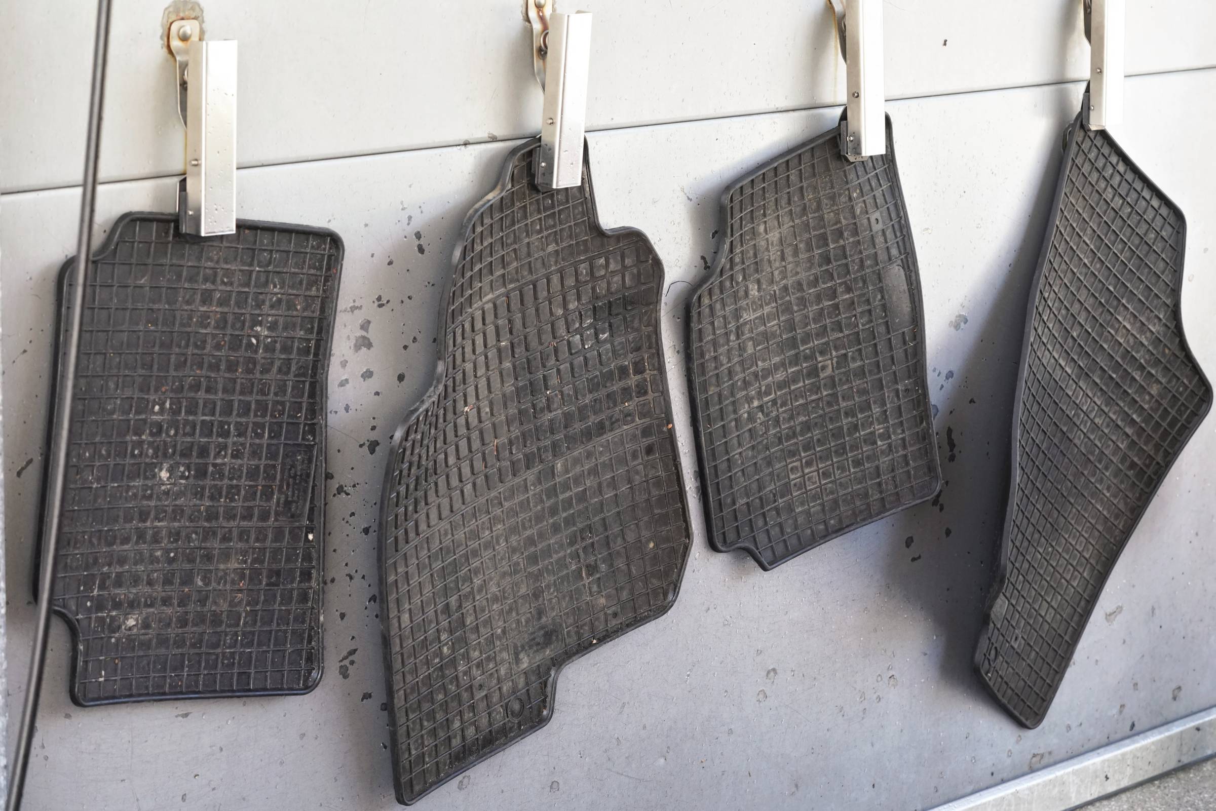 four dirty car mats to be cleaned