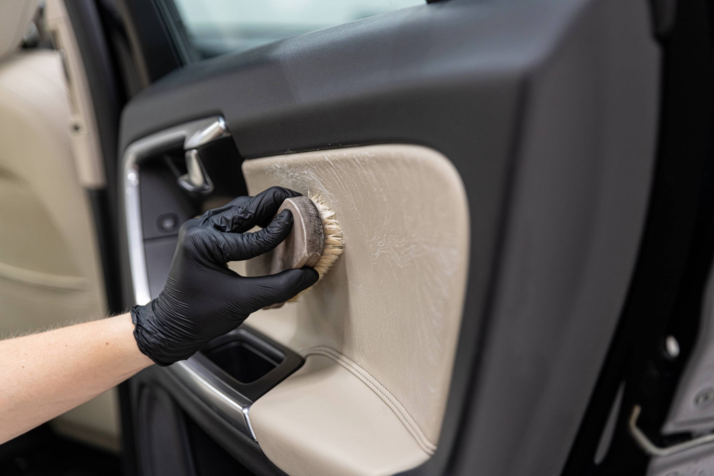 a person cleaning the inside of a car door