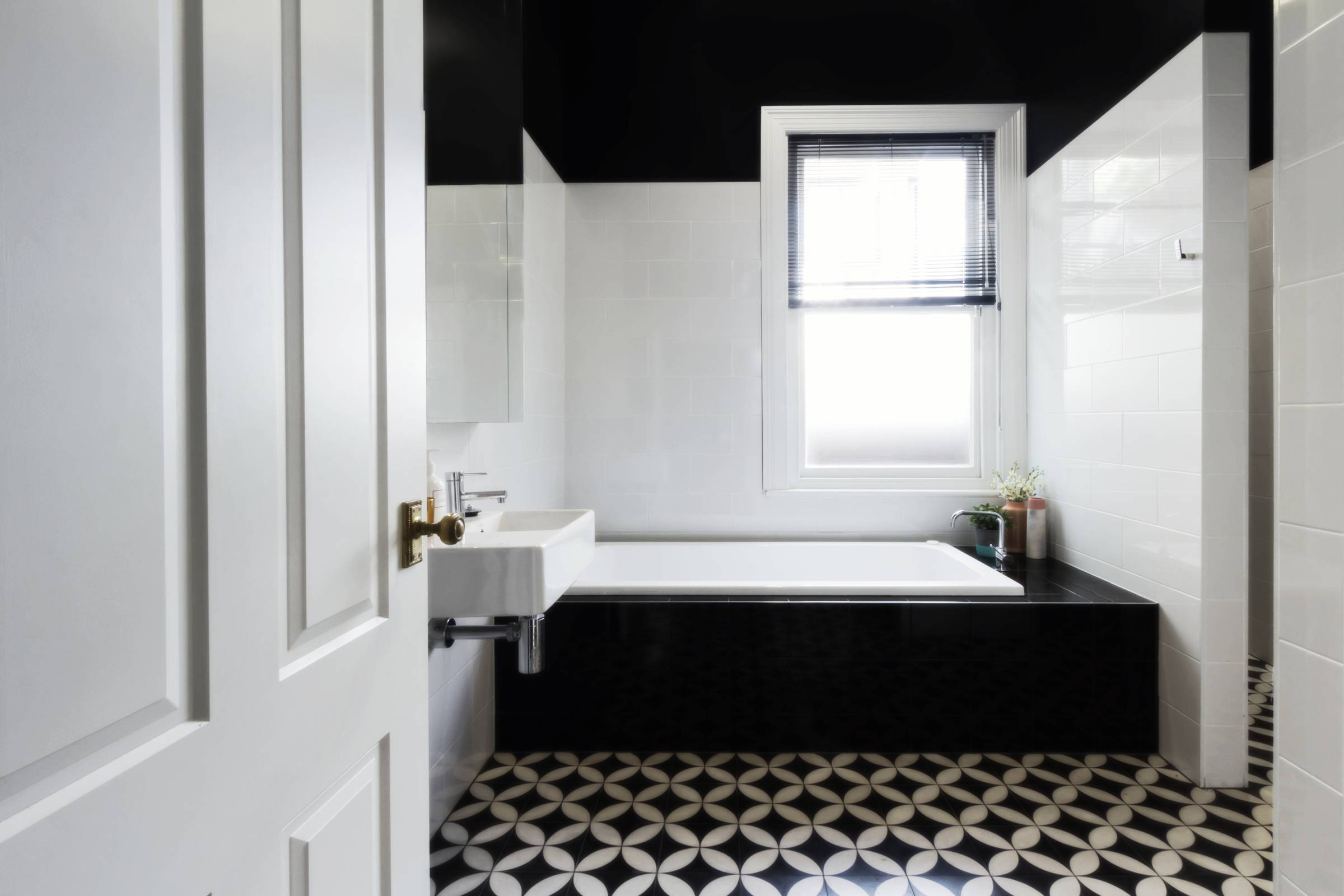 a bathroom with black and white flooring