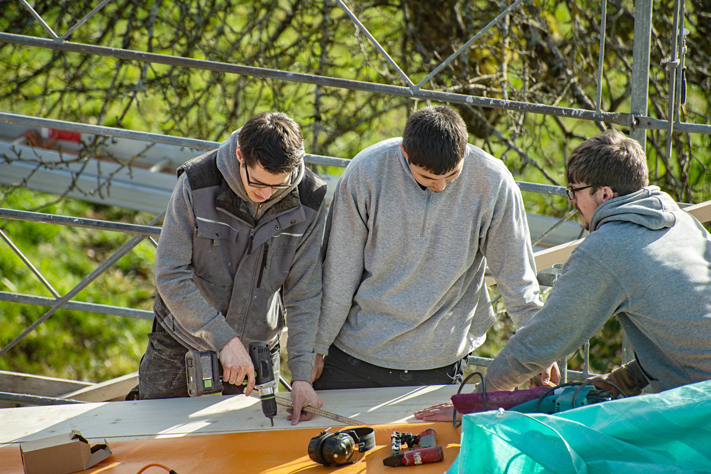 Three young carpenters working on a roof
