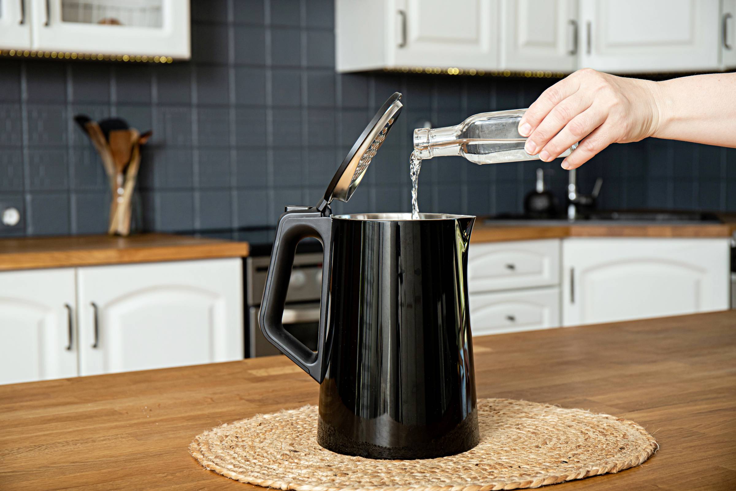 pouring white vinegar into an electric kettle