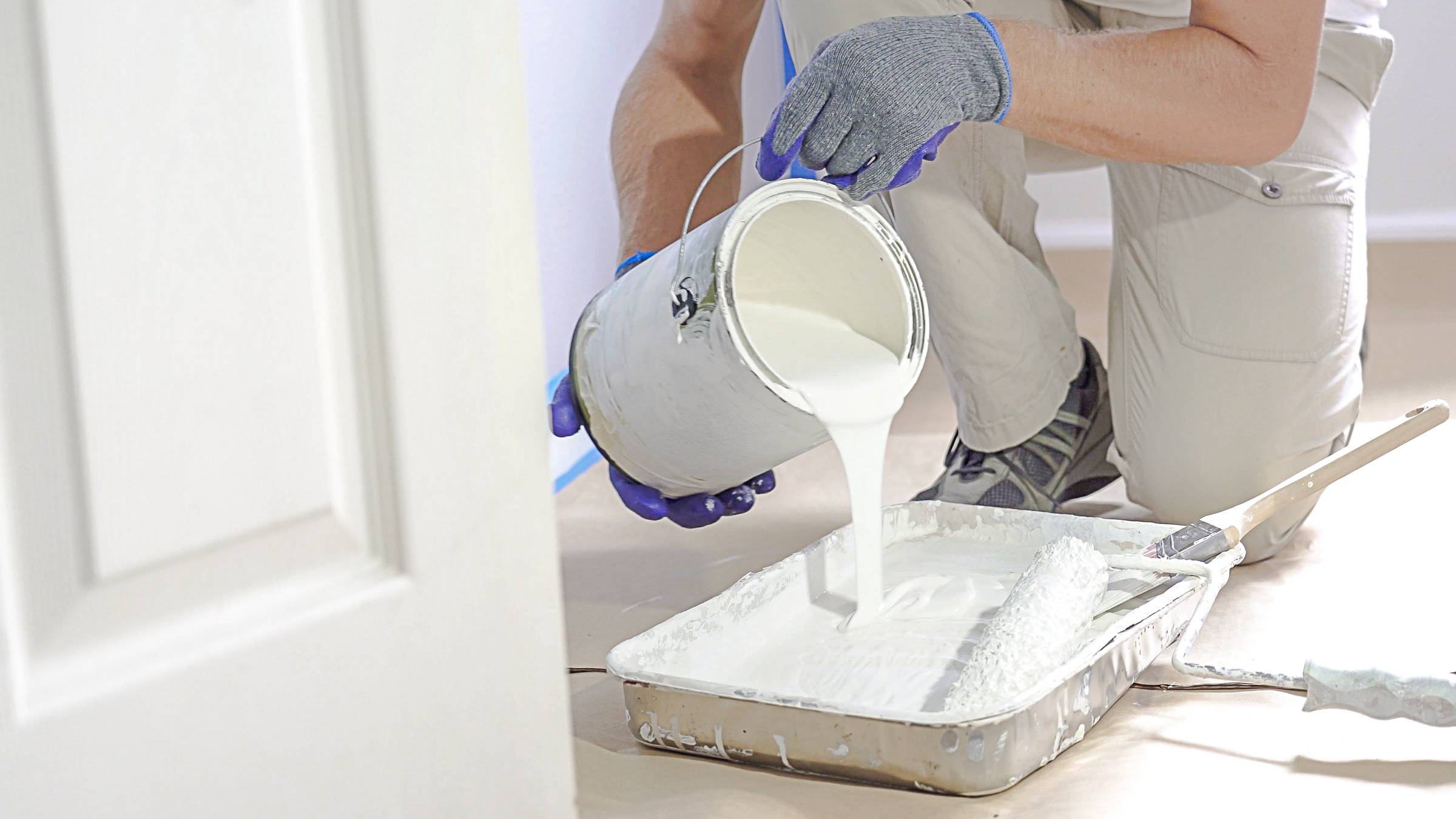 a man preparing to use white wall paint