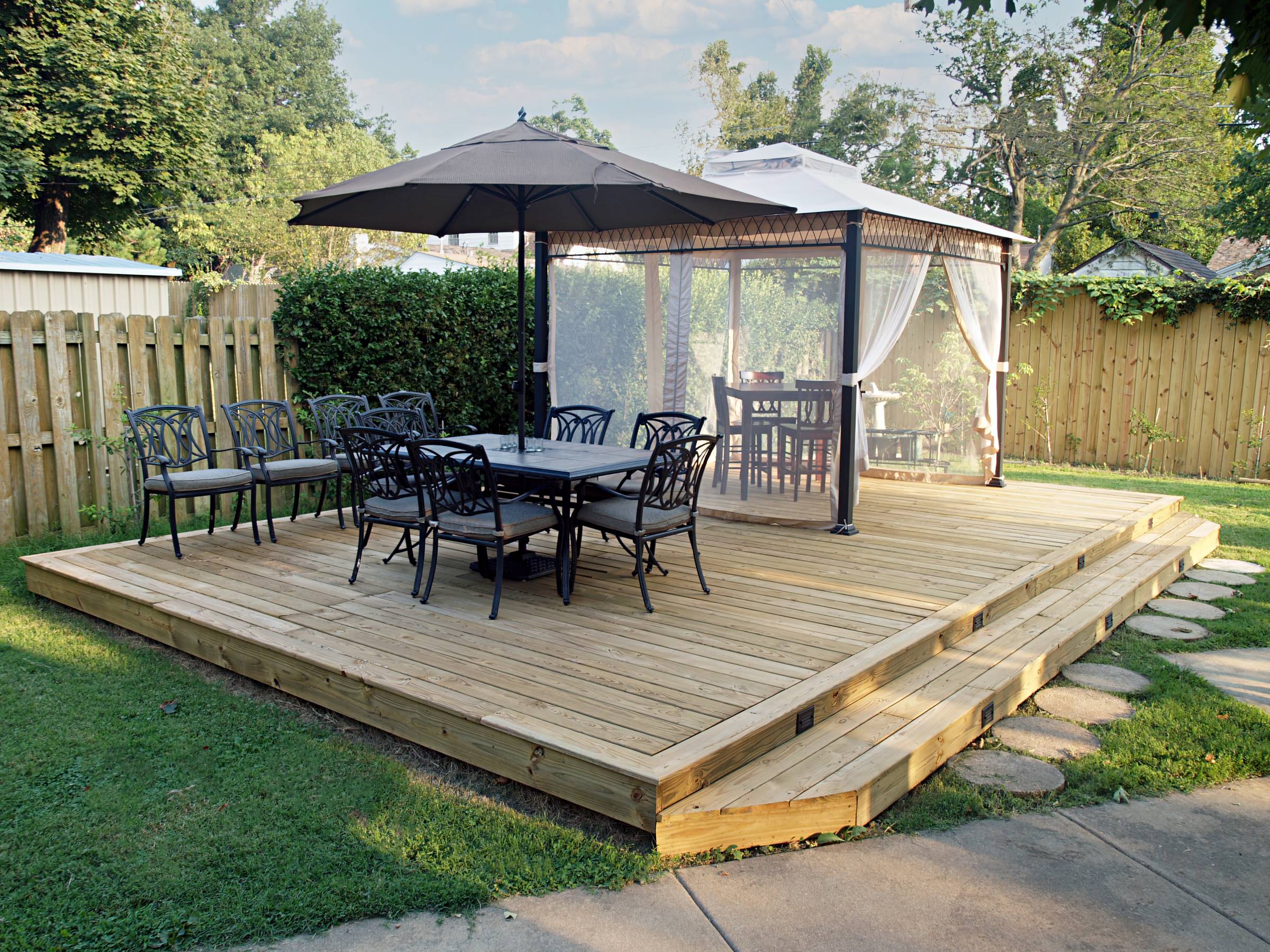 a wooden deck with shaded seating areas