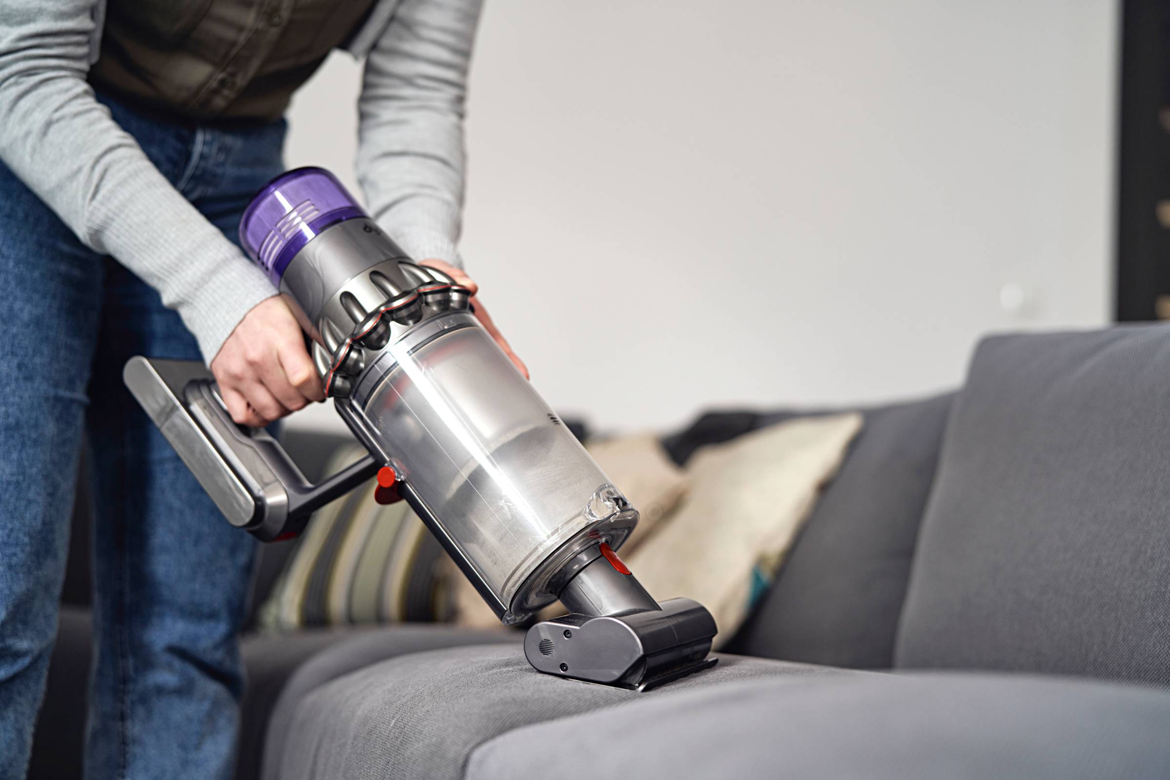 a woman using a cordless vacuum cleaner