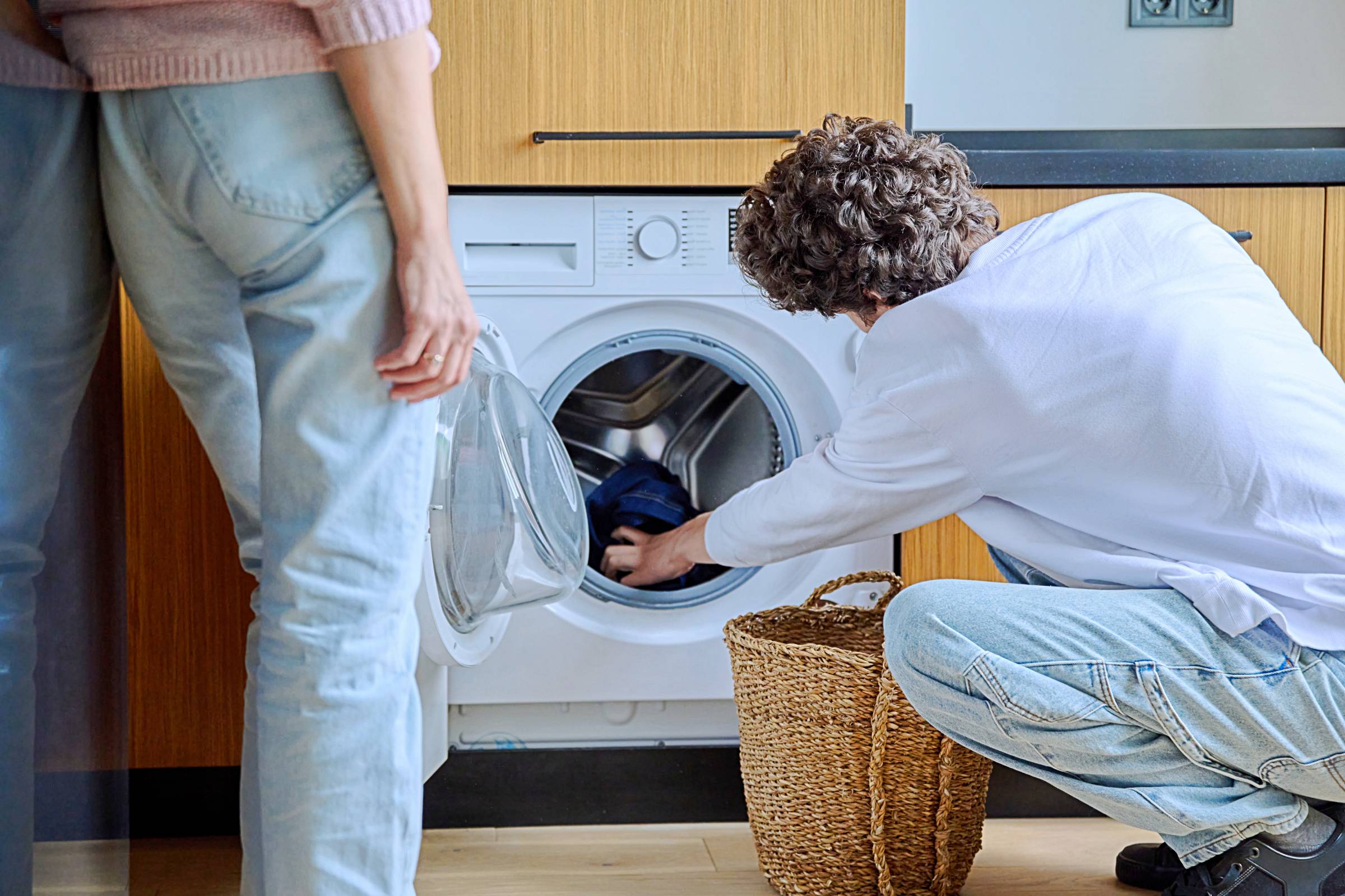 two people using a front-load washer