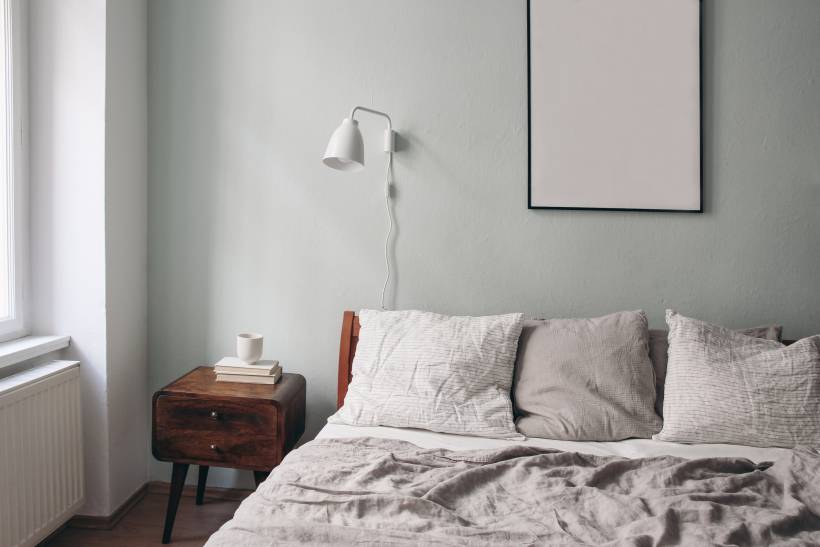 a comfy bedroom with a grey-painted wall