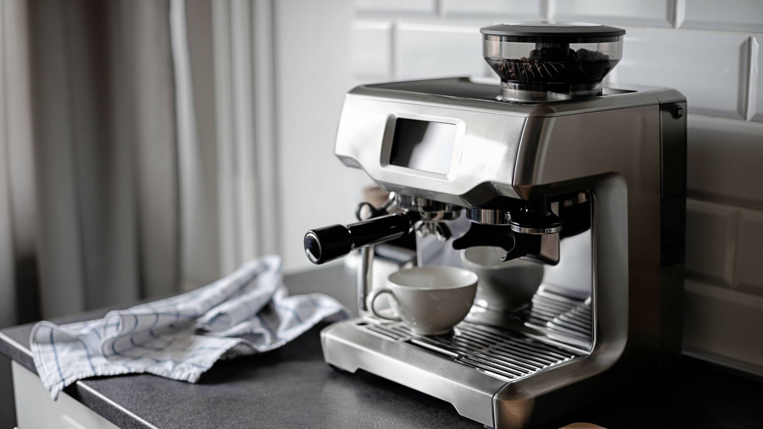 a modern coffee machine in a black and white kitchen