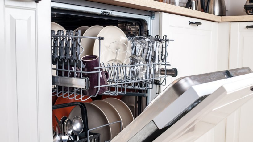 Integrated vs freestanding dishwasher: a close-up of a fully integrated dishwasher with washed dishes