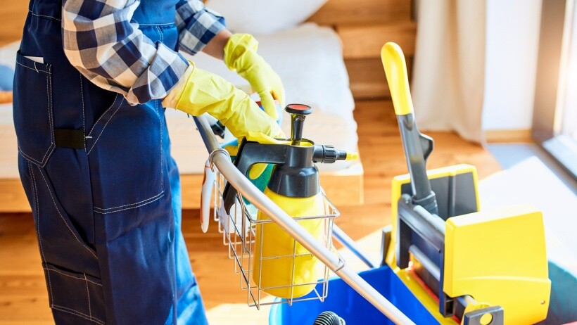 Steam cleaning carpets vs shampooing - a janitor with cleaning equipment, carpet cleaner, detergents for cleaning bedroom