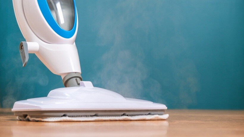 Steam mop, spin mop, or regular mop - a person washes the floors with a steam mop.