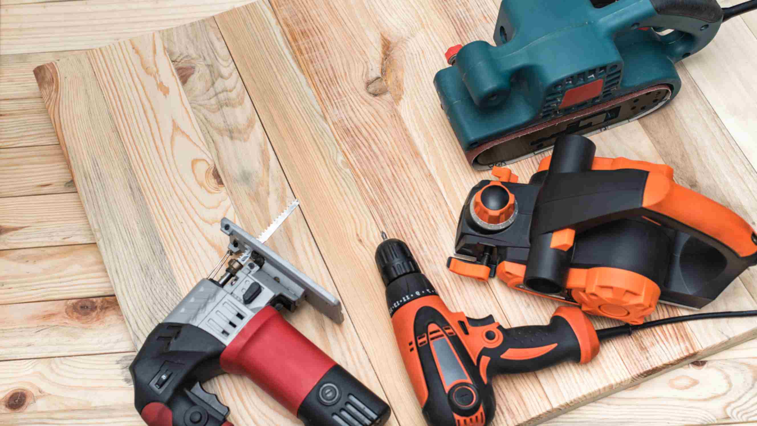 Impact driver vs impact wrench - Set of handheld woodworking power tools on a light wooden background