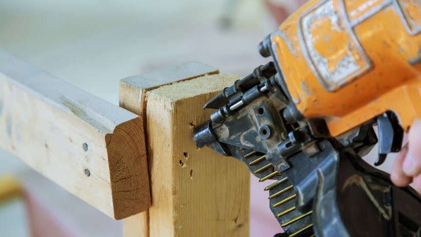 Nail gun vs staple gun - A handyperson framing up a wall section using a nail gun