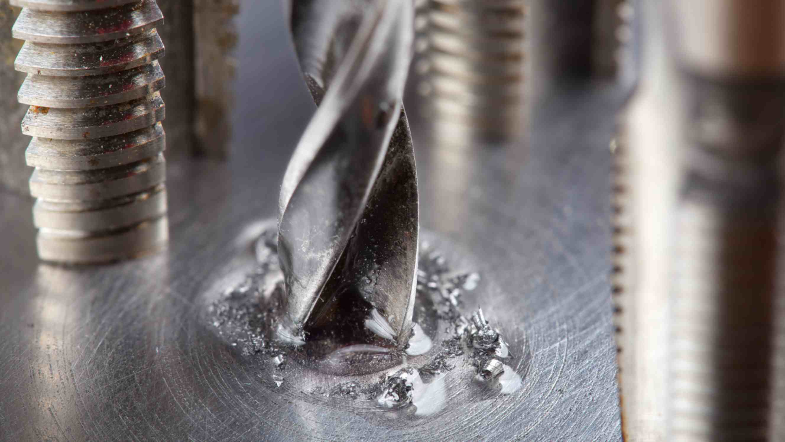 Metal drill bit vs wood - Metal drill bit with lubrication oil liquid make holes in steel billet 