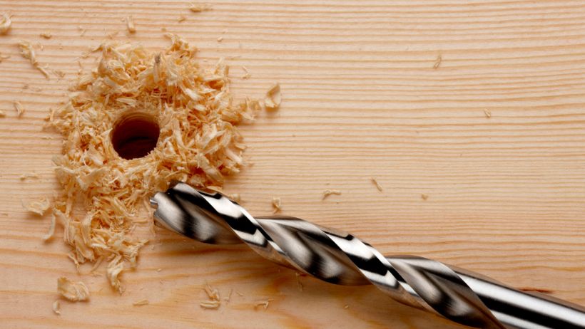 Metal drill bit vs wood - Drill bit with newly drilled hole and wood shavings